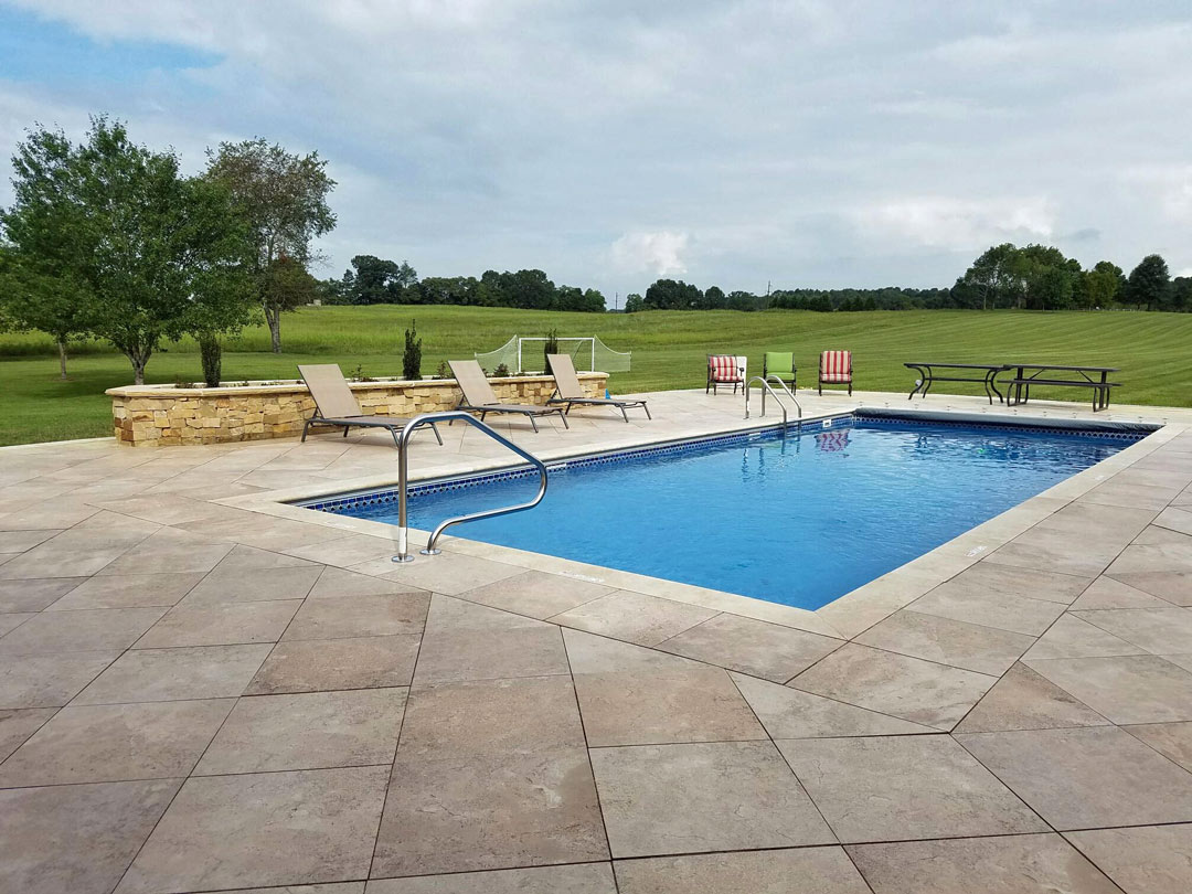 Swimming Pool With Large Tile Pavers and Raised Bed Garden Border
