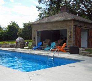 Pool house cabana next to a fiberglass inground pool.