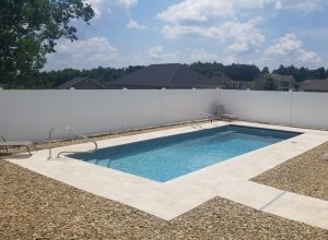 Liner pool with entry stairs in small backyard in subdivision