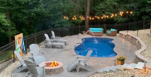 A small lagoon pool with a firepit and fountains on a steep terraced hill