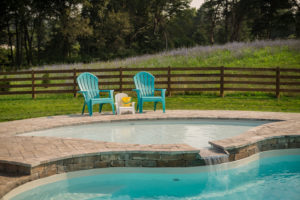 A large tanning ledge cascades via waterfall into the main lagoon pool