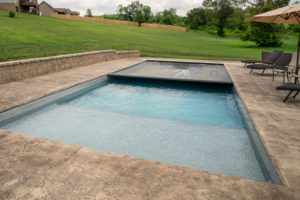 Pool safety cover shown partially retracted