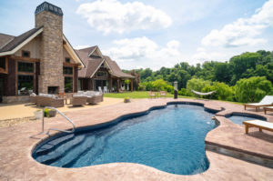 Deluxe outdoor living area with extensive hardscaping and lagoon pool