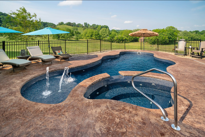 Dark and inviting fiberglass pool with water fountain and rolling hills of field and forest in the background near Johnson City, TN
