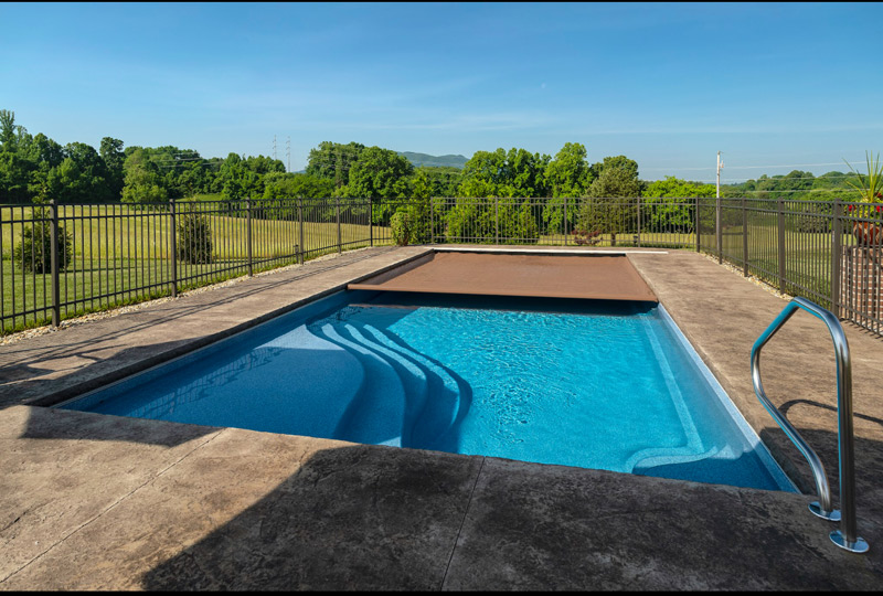A retractable safety cover is shown partially deployed on this large rectangular pool