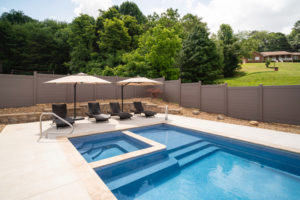 Very geometric detail shot of end of fiberglass pool with integrated hot tub, stairs, bench seating, and tanning ledge