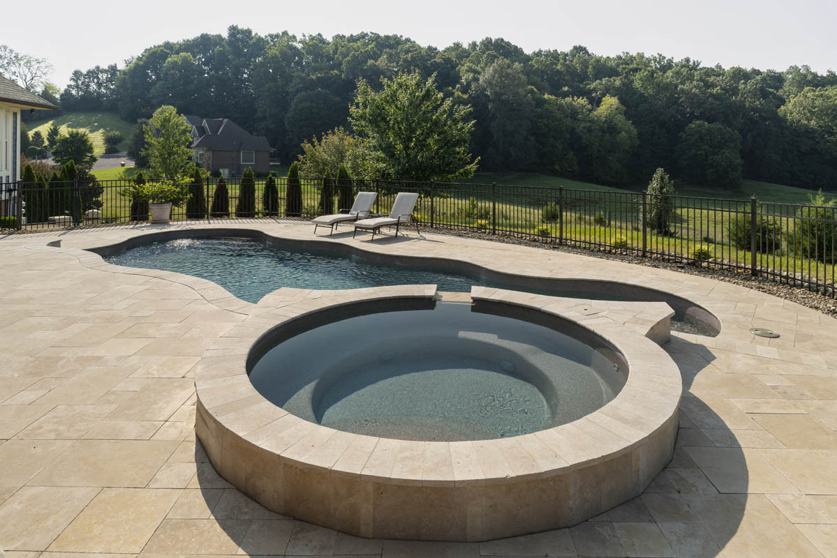 A circular jetted tub with concrete tile surround makes a perfect companion to the inground fiberglass pool