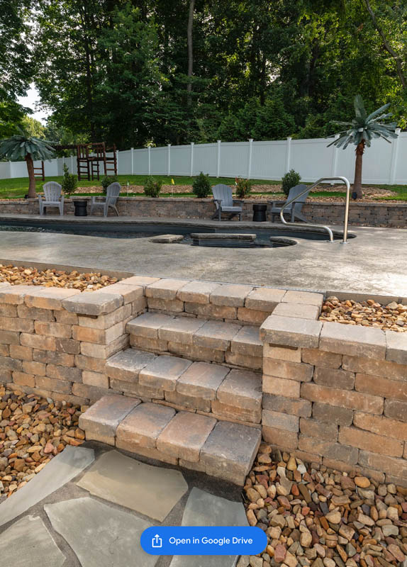 Detail photo of masonry stairs built into a retaining wall with beautiful faux stone