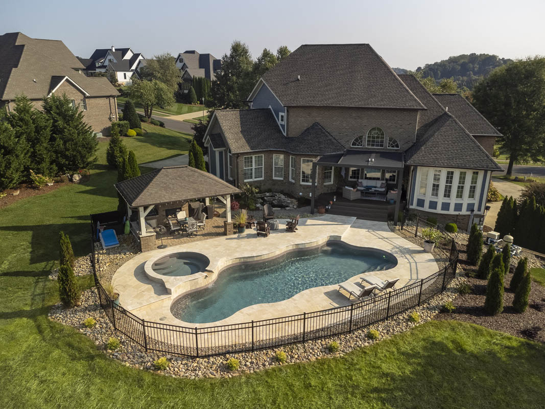 Overhead drone photography of a full-featured backyard paradise centered on a multi-level inground pool installation