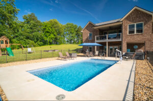 A back to basics rectangular swimming pool and simple decking with an ADA compliant handicapped pool lift for accessibility