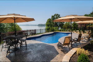 Fiberglass swimming pool installed on a steep hill overlooking lake and mountains