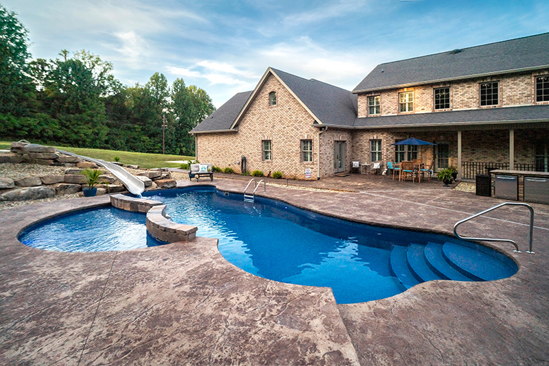 This home in Rogersville Tennessee now boasts a large inground fiberglass swimming pool surrounded by stone textured concrete decking