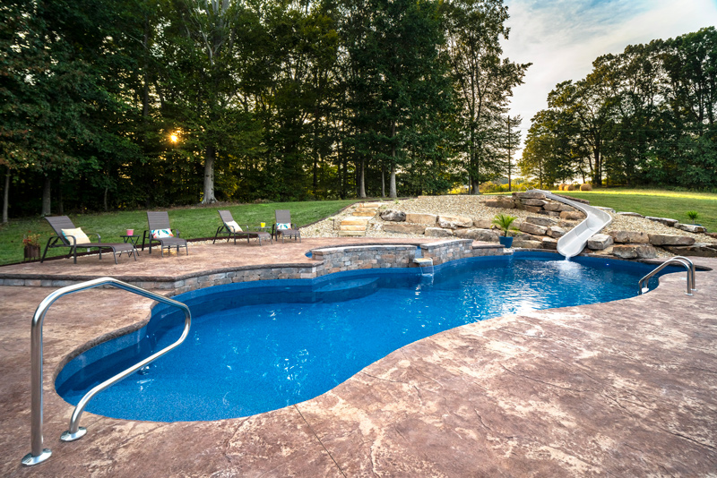 A large 24 foot waterslide and plenty of room for lounge chairs sit opposite the house by this pool