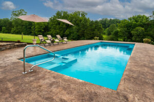 Contemporary pool in bright aqua with built in soaker spa alongside a hay field in Gray, TN