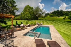 Large pool and firepit area surrounded by perfectly maintained lawn with rolling hills in background near Boones Creek in East TN