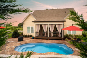 Organic shaped lagoon pool in a beautiful petite backyard with elegantly draped back porch