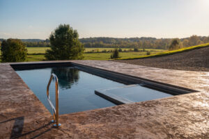 Large rectangular pool overlooks farm fields and forested hills stretching into distance in East Tennessee near Blue Ridge Mountains
