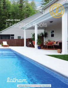 Thumbnail image of Latham Pool catalog with rectangular lap pool just a few steps across the patio from a very traditional looking American home with beige lap siding
