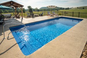 modest fiberglass pool installation with various lounge areas alongside it