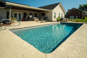 small inground lap pool with textured concrete decking
