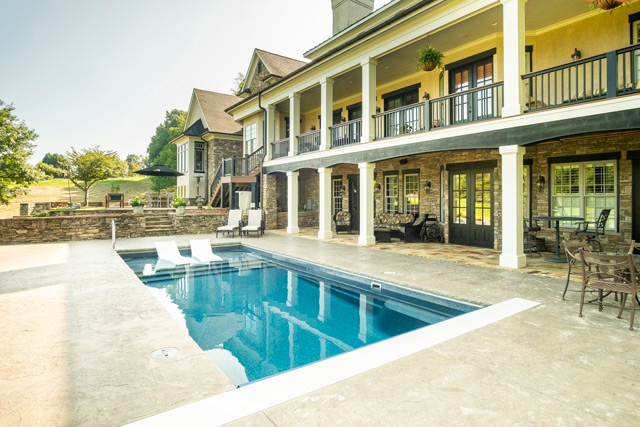 Large rectangular pool installed close alongside long back edge of stylish home